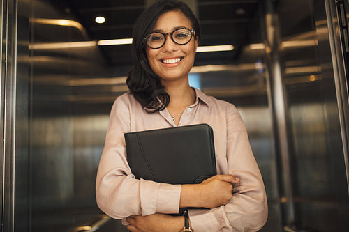 Smiling business woman in office elevator