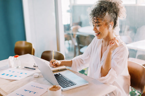 Smiling businesswoman having a virtual meeting in a cafe