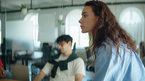 Woman leads a business meeting while speaking and listening to coworkers in the office