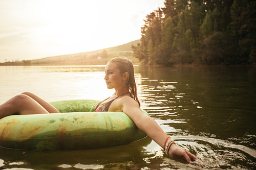 Young woman in lake on inflatable ring