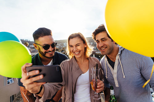 Young friends partying together taking selfie