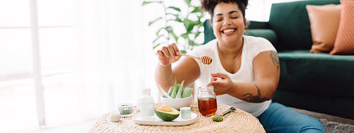 Beautiful woman using honey for skincare at home