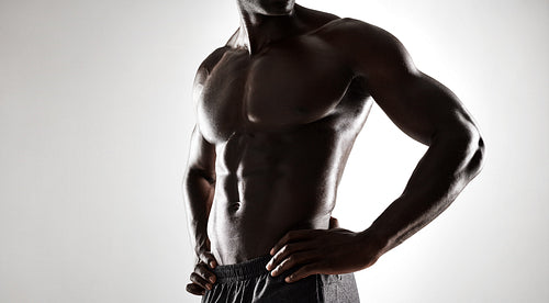 African man with muscular body on grey background