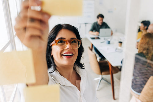 Business woman brainstorming with sticky notes in an office
