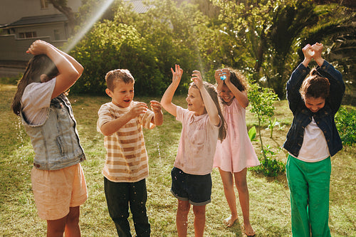 Group of happy children having fun playing outdoors together