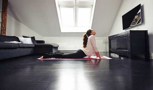 Young brunette exercising on floor at home