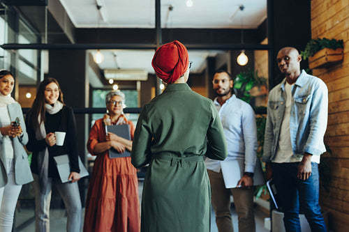 Rearview of a manager giving a speech during a meeting in an off