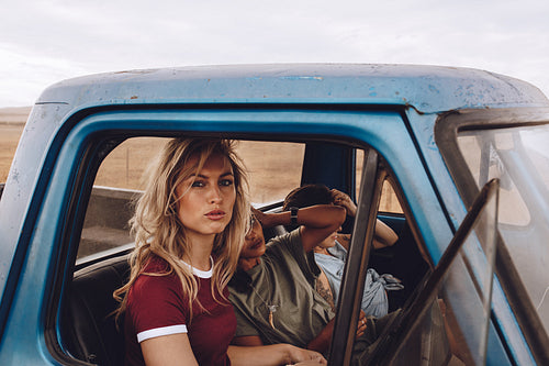 Female friends on road trip traveling by a car