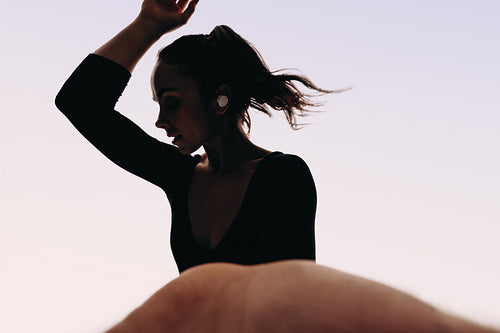 Expressive female dancer recording herself while listening to music in a studio