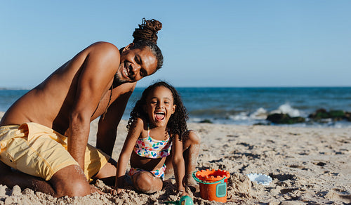 Happy father and daughter enjoying a sunny beach vacation together