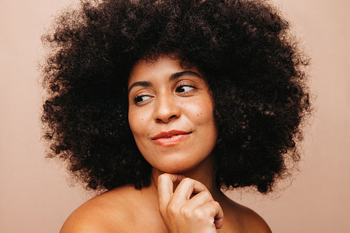 Woman with Afro hair looking away pensively