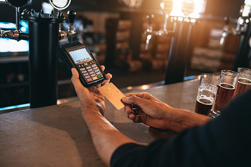 Man paying using a credit card at bar