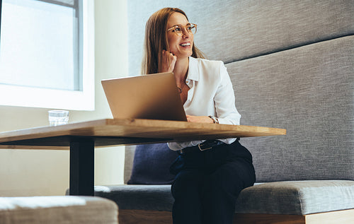 Excited businesswoman looking away thoughtfully