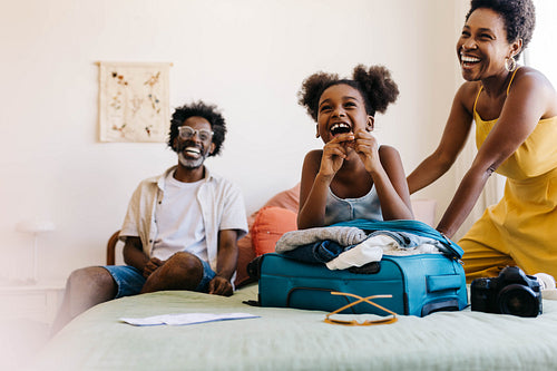 Family vacation preparation: Mom and daughter packing travel bag together