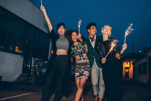 Friends playing with sparklers on road