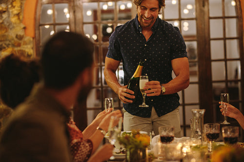 Man serving drinks to friends at party