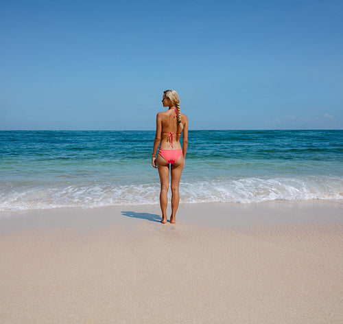 Young woman standing on serene beach