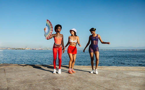 Three friends dancing in colorful beach outfits