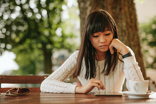 Attractive girl using digital tablet at coffeeshop