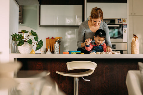 Little boy having fun making cookies with mother