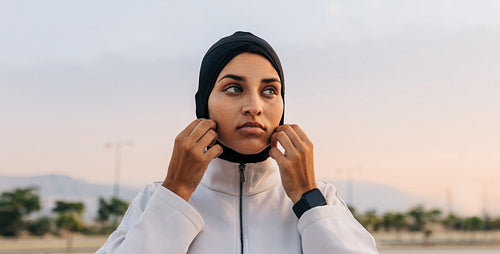 Sportswoman adjusting her headscarf outdoors