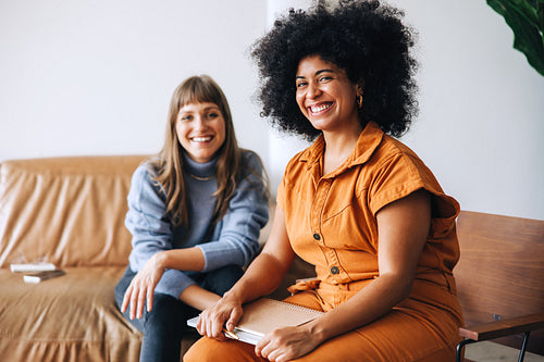 Successful businesswomen smiling at the camera in an office lobby