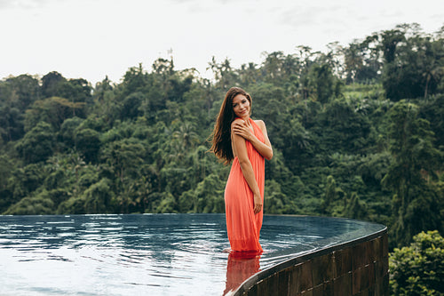 Beautiful young female model posing in swimming pool