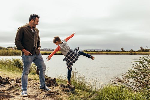 Father and son playing near the lake