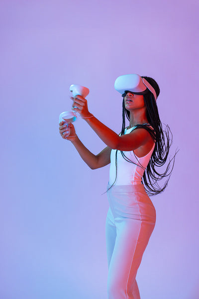 Woman with braids playing a virtual reality game in a studio