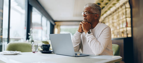 Thoughtful businessman working in a cafe