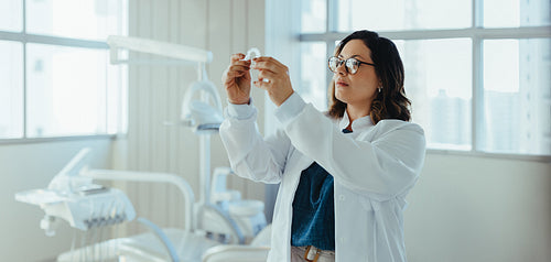 Dentist woman examining dental model in a modern clinic portrait