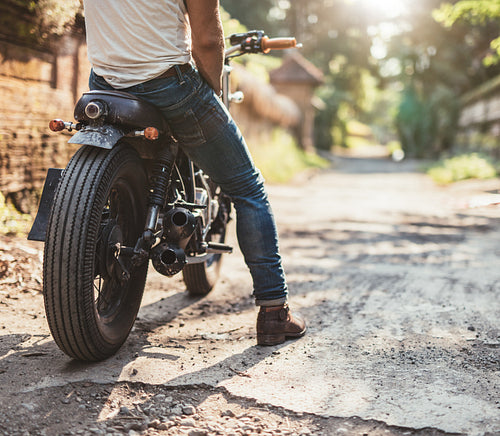 Young man on his motorcycle on dirt road
