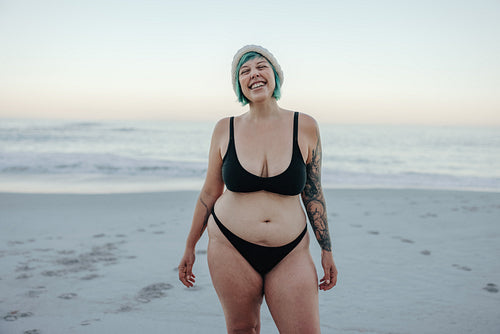 Excited winter bather smiling with her eyes closed at the beach