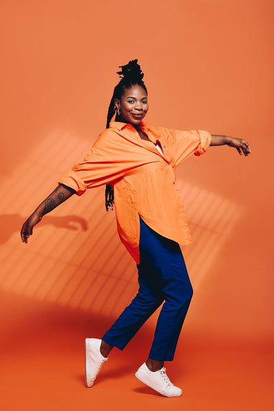 Fashionable black woman dancing in casual clothing in a studio