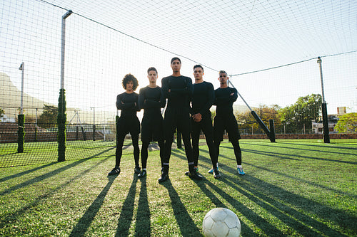 Soccer players standing together on pitch