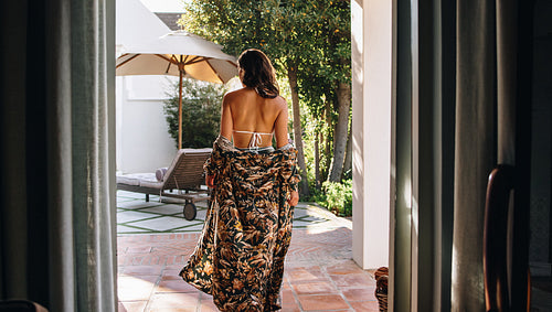 Rearview of a woman in a gown and a bikini at a spa resort