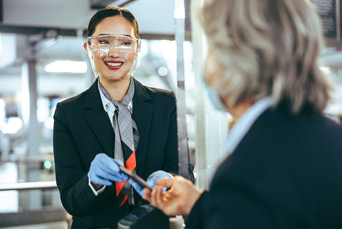 Flight attendant assisting passenger at check in counter