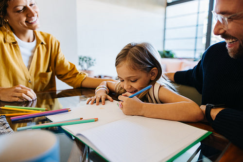 Family at home: child draws with parents