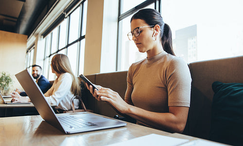 Businesswoman reading a text message in a co-working space