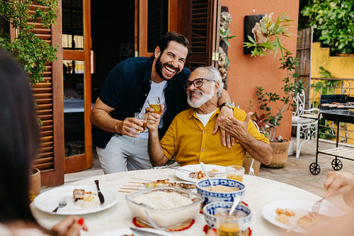 Father and son enjoying a family barbecue in a sunny outdoor setting