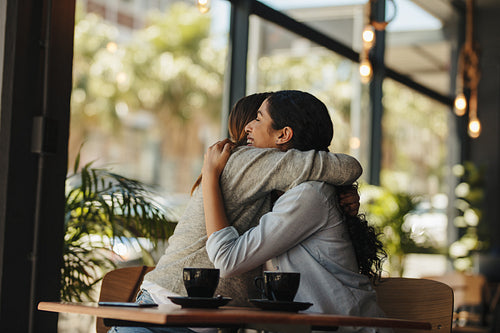Friends greeting each other with a hug