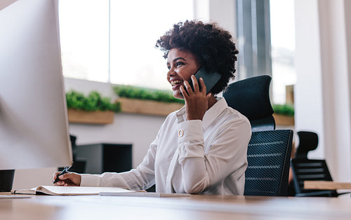 Smiling businesswoman talking with client over phone