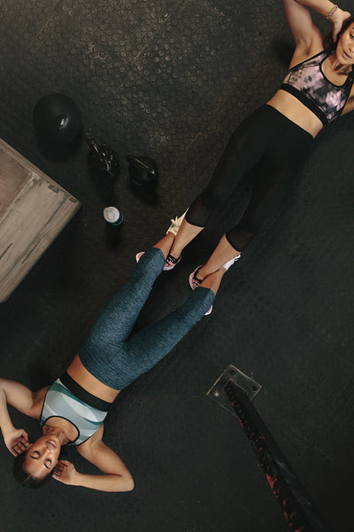 Women doing sit-ups together at gym