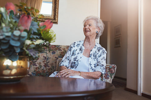 Senior woman sitting on a sofa at old age home