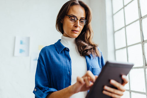 Business woman using a touchscreen tablet in an office
