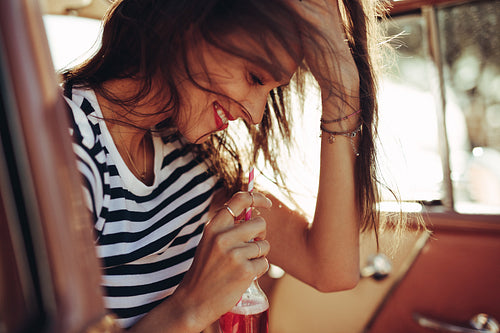 Smiling young woman sitting in car