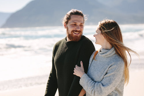 Handsome man walking with his girlfriend at the beach