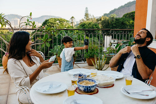 Family enjoying a patio meal together in a tropical outdoor setting