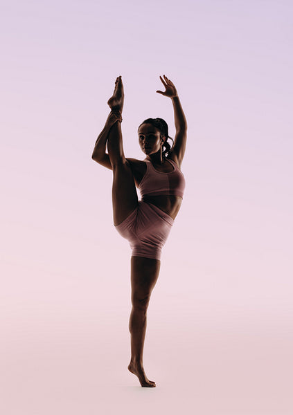 Ballerina showcasing expertise in classical dance routine as she stands on one leg