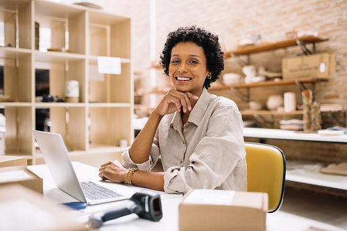 Happy young businesswoman smiling at the camera in a warehouse